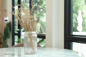 The dried flowers in the vase on the table are used to decorate the coffee shop. photo