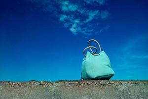 concepto de viaje de verano. bolsa de playa azul y cielo azul foto