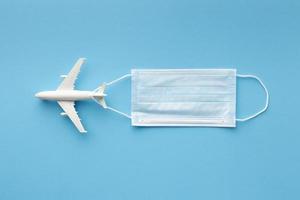 flat lay medical mask with airplane figurine