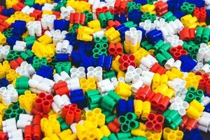 Multicolored plastic building blocks of the designer. Background of plastic colored details building blocks photo