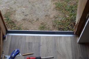 Installation of thresholds and baseboards in the interior of a residential building photo