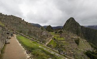 MACHU PICCHU, PERU, JANUARY 3, 2018 - Unidentified people at remains of ancient Inca citadel in Machu Picchu, Peru. Almost 2500 tourists visit Machu Picchu every day. photo