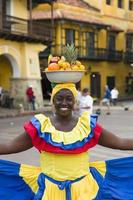 CARTAGENA, COLOMBIA, SEPTEMBER 16, 2019 - Unidentified palenquera, fruit seller lady on the street of Cartagena. These Afro-Colombian women come from village San Basilio de Palenque, outside the city.