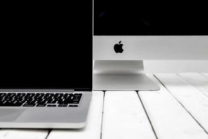 BELGRADE, SERBIA, MARCH 8, 2017 - iMac computer and MacBook laptop on the table. iMac is a range of all-in-one Macintosh desktop computers designed and built by Apple Inc photo