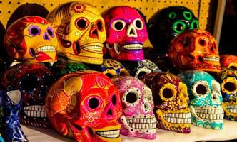 cabo san lucas, méxico, 8 de agosto de 2014 - calacas, cráneo de madera máscaras del día de los muertos en el mercado de cabo san lucas, méxico. las máscaras son símbolos típicos que representan calacas, esqueletos.