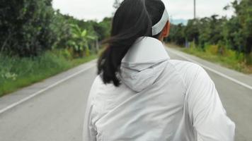 Gros plan d'une femme qui court sur le sentier de la route le matin video