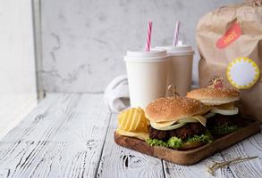 Set of homemade burgers, chips and drink photo
