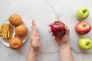 Apples vs french fries and burgers top view flat lay photo