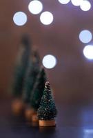 Christmas tree decorations standing in the line with fairy lights background with copy space
