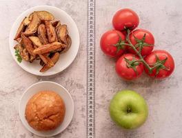 Fruit and vegetables vs sweets and potato fries top view flat lay photo