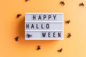 Feliz caja de luz de cine de halloween con arañas vista superior sobre fondo naranja foto