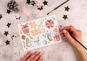 Woman hands painting a christmas pictures flat lay top view photo