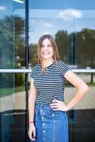 caucasian woman in casual clothes smiling on urban building background photo