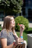 happy beautiful caucasian woman blowing soap bubbles outdoor in a sunny day