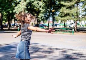 Happy caucasian woman in casual clothes smiling and having fun in the park in summer sunny day photo