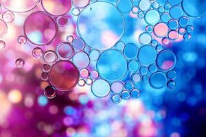 Burbujas de aceite azul y púrpura en el agua con patrón abstracto foto