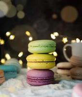 stack of macaroons on the table, fairy lights and bokeh background photo