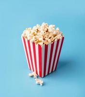 classic red and white box of popcorn isolated on blue photo