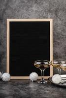 empty black felt letter board with champagne glasses and new year decorations photo
