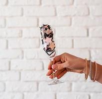 Woman hand with a glass full of confetti photo