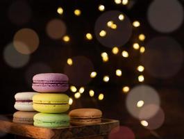 stack of macaroons on the table, fairy lights and bokeh background photo