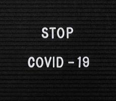 The words Stop Covid-19 on black felt letter board photo