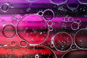 Pink and purple abstract pattern made with oil bubbles on water coming up in motion photo