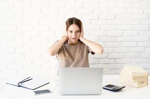 Shocked teen schoolgirl looking at the laptop photo