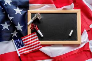 Blank chalkboard with a piece of a white chalk and noisemakers with american flags flat lay top view photo