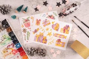 Artist workspace with painted pictures, paintbrushes, confetti and decorations top view flat lay photo