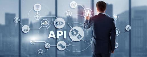 Application Programming Interface. API software development tool. Information technology concept. Businessman presses API text icon on a virtual interface photo