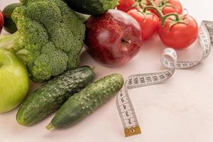 verduras y frutas frescas para una dieta saludable y una cinta métrica foto