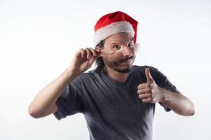 Latino man with Christmas hat with a candy cane. photo