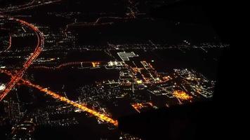 Blick aus dem Flugzeugfenster über die Stadt bei Nacht. video