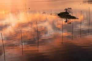 el lago de la tarde reflejaba el resplandor del atardecer y las montañas foto