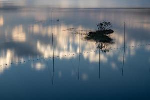 el lago de la tarde reflejaba el resplandor del atardecer y las montañas foto