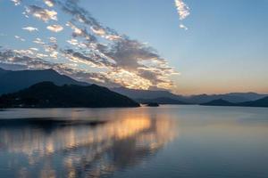 el lago de la tarde reflejaba el resplandor del atardecer y las montañas foto