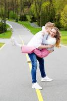 Beautiful couple fooling around on the street on green forest background