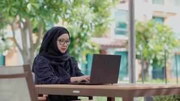 mulheres muçulmanas sentadas do lado de fora trabalhando de acordo com o slogan trabalhe em casa, ela estava trabalhando em uma residência particular. video
