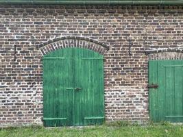Casa de campo de pueblo europeo antiguo granero con puerta verde foto
