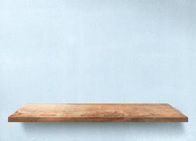 Empty wooden shelf on concrete wall. photo