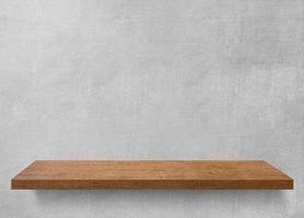 Empty wooden shelf on concrete wall. photo