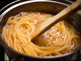 espaguetis crudos se cocinan en agua hirviendo en una olla de cocina. conceptos de cocina y comida italiana saludable.
