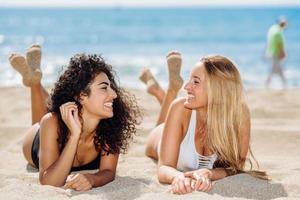 Dos mujeres jóvenes con hermosos cuerpos en traje de baño en una playa tropical foto