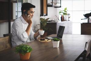 asian man sitting in the cafe, drinking coffee and breakfast, woking form the distance. business and technology concept photo