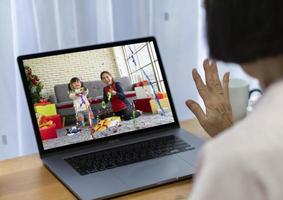 senior woman celebrate christmas with family via video call photo