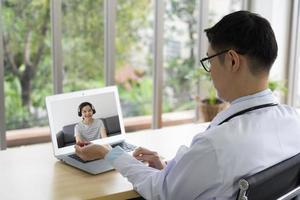 joven médico asiático que muestra cómo palpar el pulso radial al paciente a través de una videoconferencia. telemedicina y concepto médico online foto