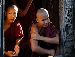 portrait of group of asian novice monk in sitting at door of temple photo