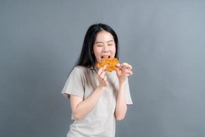 Young asian woman with happy face and enjoy eating fried chicken photo