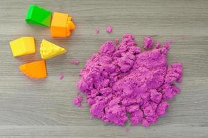 bright pink kinetic sand in the hands of a child. Development and education. Fine motor skills